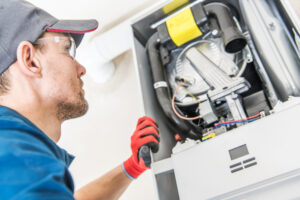 A heating technician inspects a home furnace.