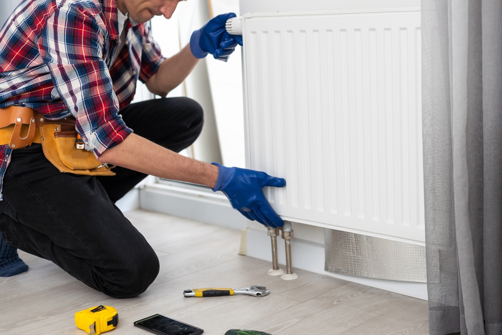 Technician installing a radiator.