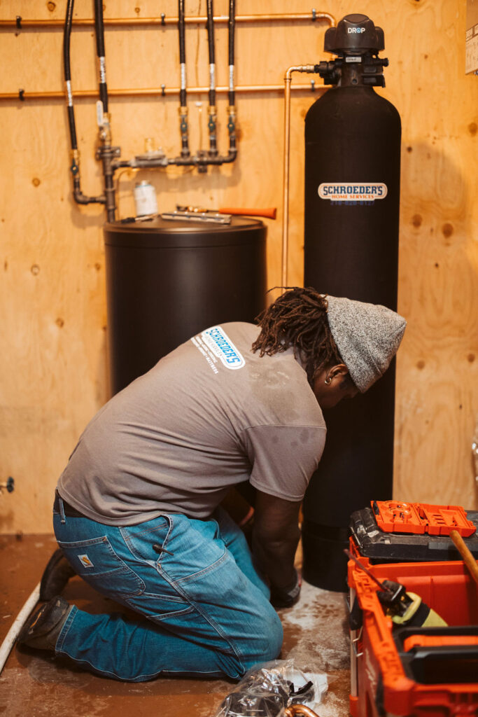 A Schroeder's plumber installs a water softener.