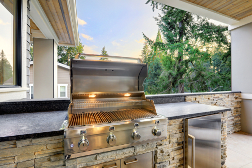 An outdoor kitchen with a built-in grill