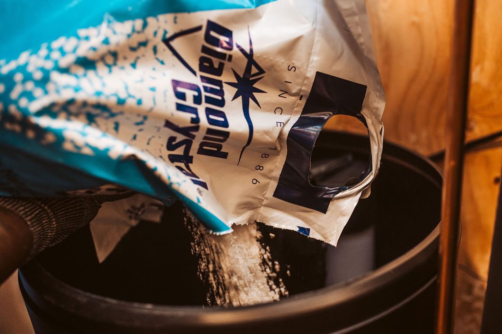 Salt crystals being poured into a water softener